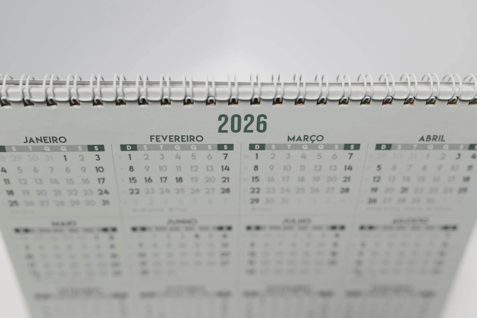 Close-up of a 2026 spiral-bound desk calendar with months in Portuguese. (Photo by Matheus Bertelli on Pexels)