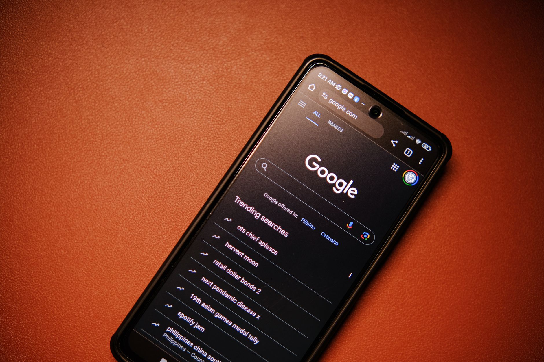 A smartphone displaying Google Search trends on a table at night. (Photo by Click Jeth on Pexels)