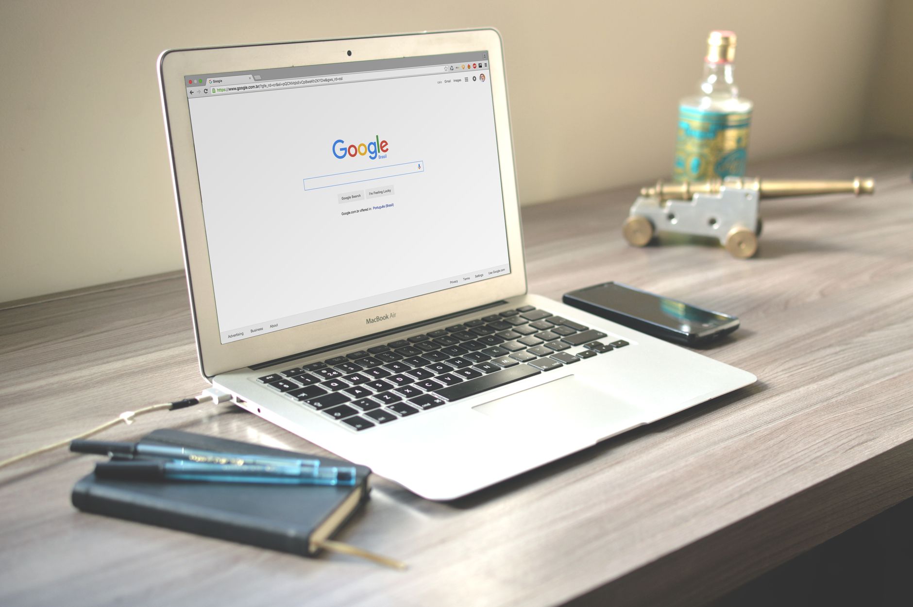 A neat workspace featuring a laptop displaying Google search, a smartphone, and a notebook on a w... (Photo by Caio on Pexels)